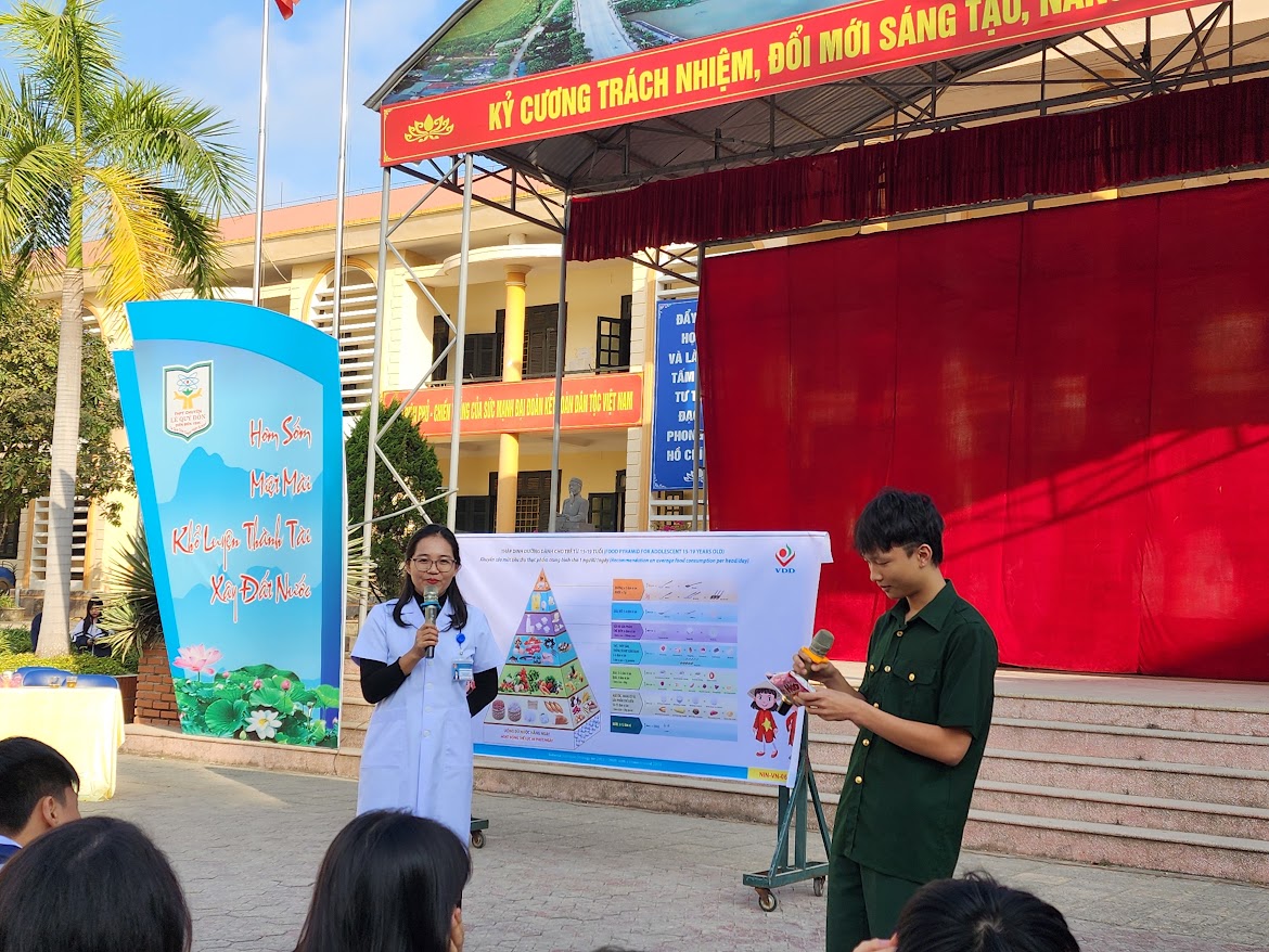 Dưỡng chất quan trọng cần bổ sung ở trẻ vị thành niên - Ảnh 1. A person and person standing in front of a stage AI-generated content may be incorrect.
