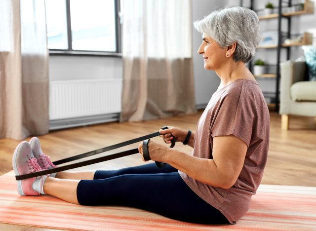 4 bài tập giúp tăng cơ sau 50 tuổi- Ảnh 4. phụ nữ lớn tuổi tập chèo thuyền với dây kháng lực, khái niệm tập luyện cho người cao tuổi để phục hồi sức mạnh
