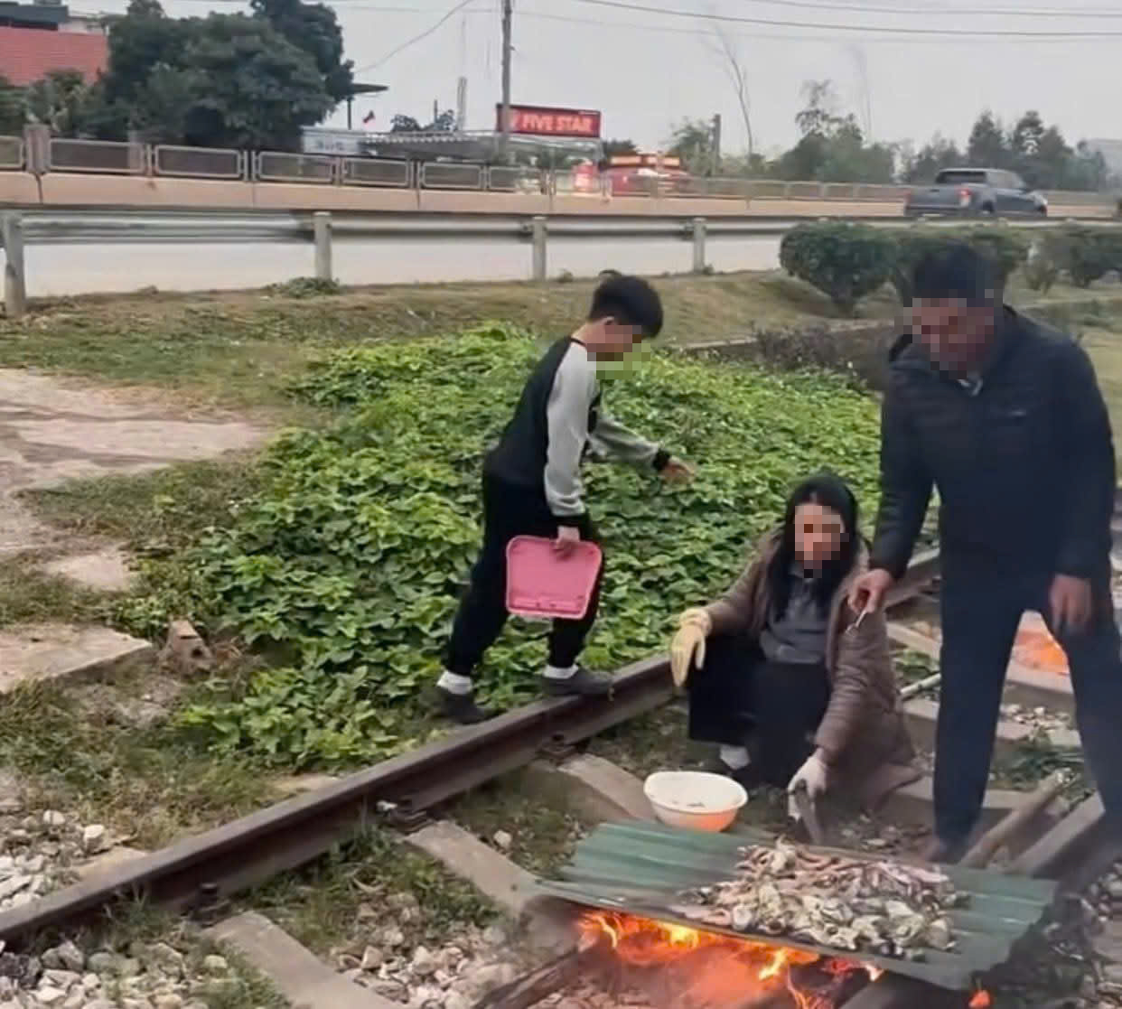 Xôn xao clip gia đình nổi lửa, nướng đồ ăn trên đường ray- Ảnh 1. Xôn xao clip gia đình nổi lửa, nướng đồ ăn trên đường ray- Ảnh 1.