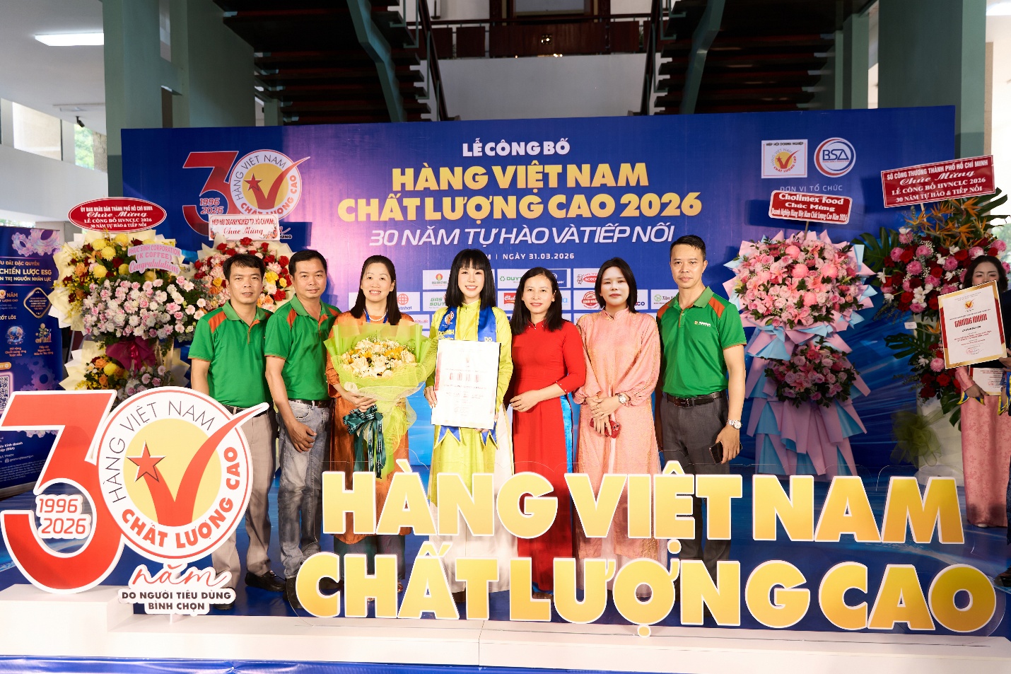 A group of people standing in front of a sign  Description automatically generated