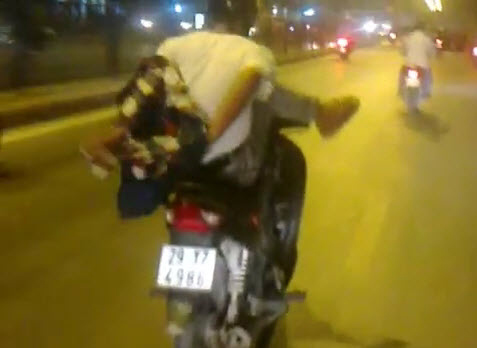 Vừa cởi áo vừa lái xe máy bằng một chân  1