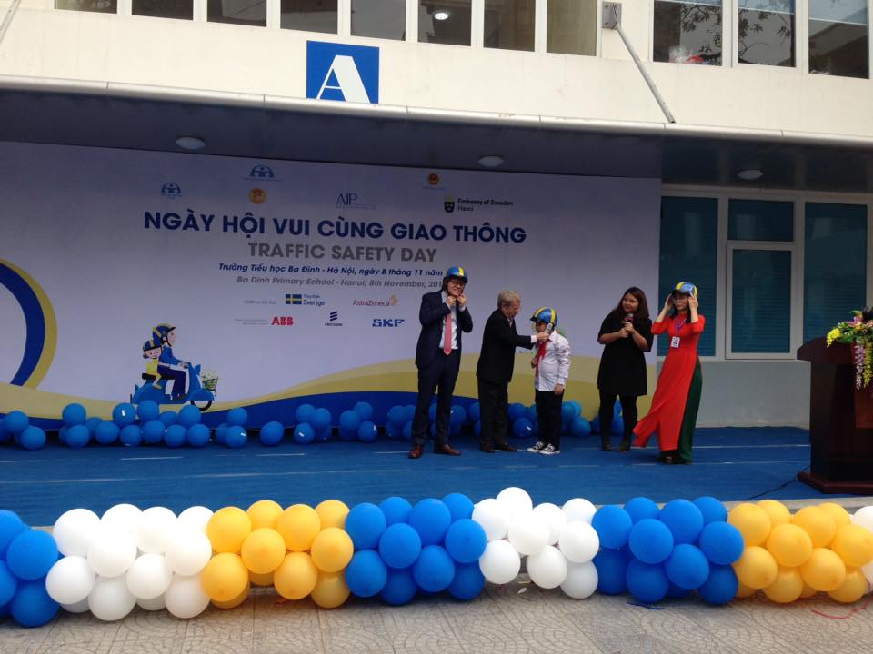 Ông Greig Craft, Chủ tịch Quỹ Phòng chống Thương vong châu Á (AIP) hướng dẫn các em nhỏ đội mũ bảo hiểm đúng cách
