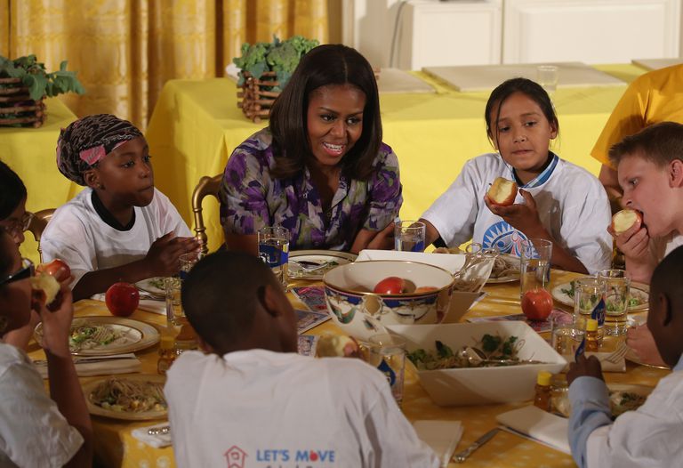 Michelle Obama hướng dẫn các em học sinh ăn nhiều rau xanh và hoa quả để tạo ra một thế hệ nước Mỹ khỏe mạnh, phòng ngừa bệnh mạn tính như béo phì, tiểu đường,....