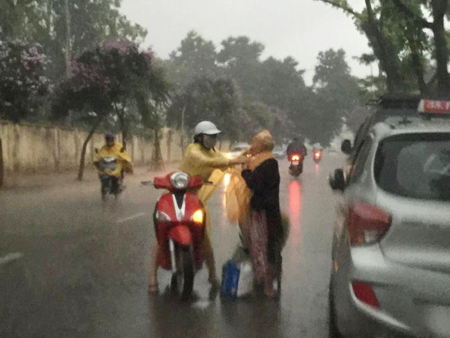 Khoảnh khắc đẹp nhất ngày mưa: Cô gái Hà Nội dừng xe, mặc áo mưa cho cụ bà trong cơn dông