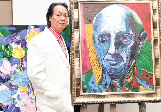 Họa sĩ Lê Đại Chúc bên chân dung Picasso.