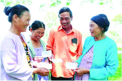 Niềm vui của người dân xã Quế Châu, huyện Quế Sơn, tỉnh Quảng Nam khi nhận thẻ BHYT. Ảnh: Thanh Dũng