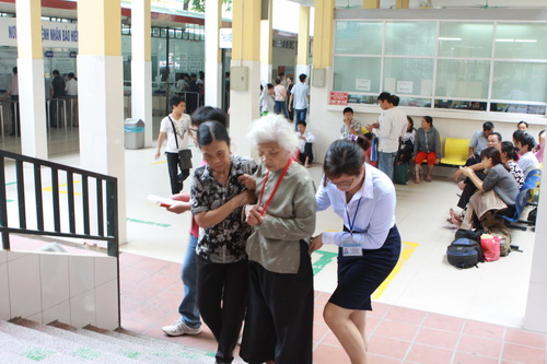 Thành viên Tổ Hỗ trợ người bệnh đang giúp đỡ bệnh nhân tại BV Việt Đức.