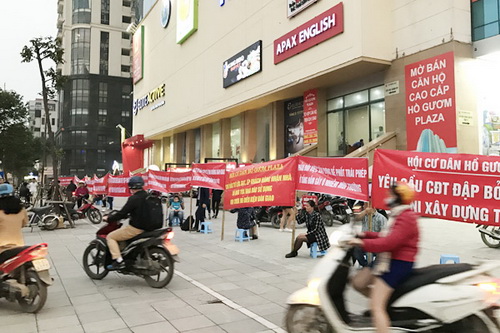 Cư dân vẫn căng băng rôn phản đối, còn chủ đầu tư vẫn mở bán căn hộ. Cư dân vẫn căng băng rôn phản đối, còn chủ đầu tư vẫn mở bán căn hộ.