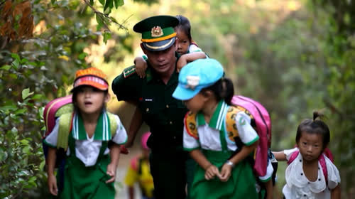 Thượng úy Trần Bình Phục cõng học trò tới lớp.