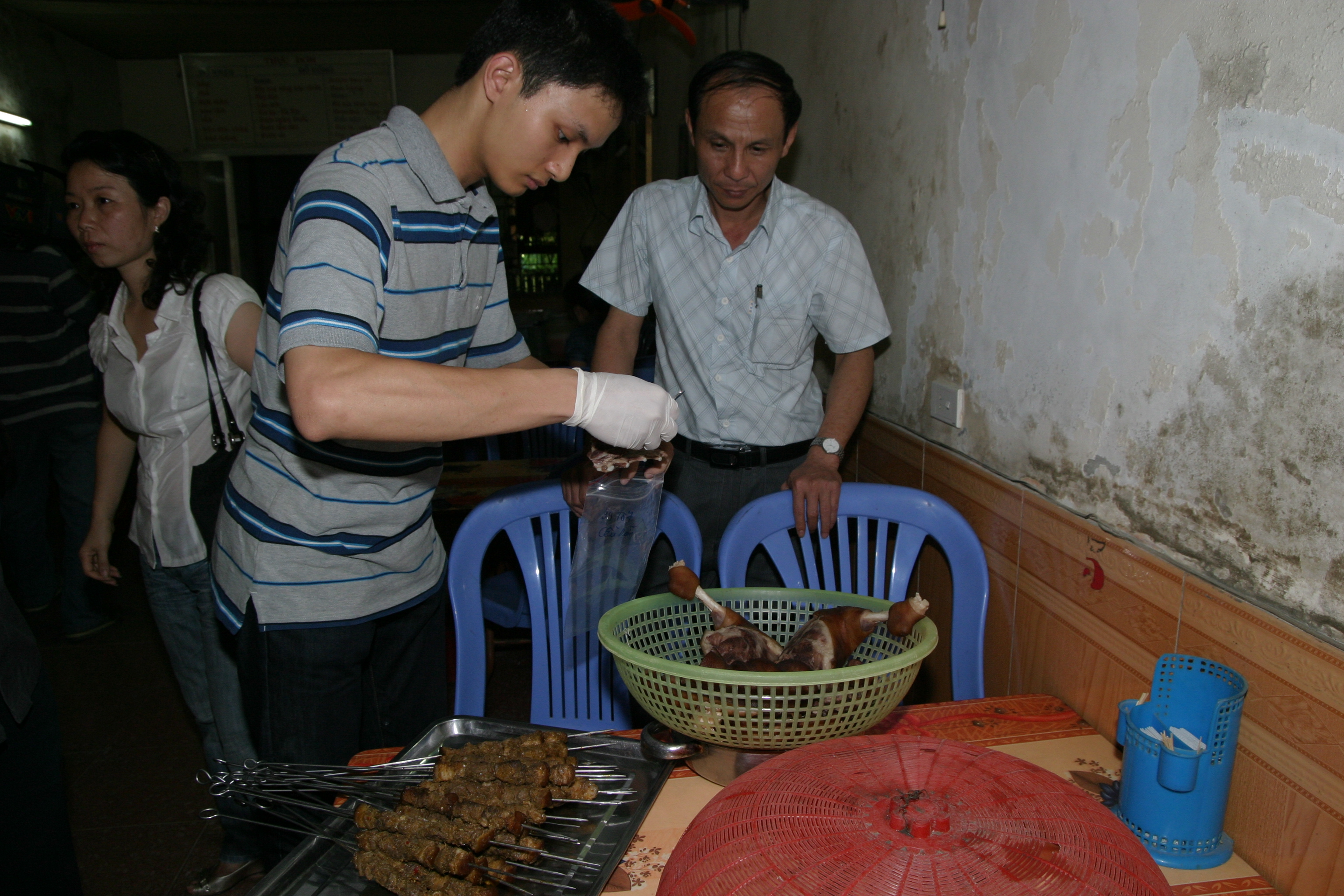 Lấy mẫu để kiểm tra  an toàn thực phẩm tại cửa hàng ăn. Ảnh: TM