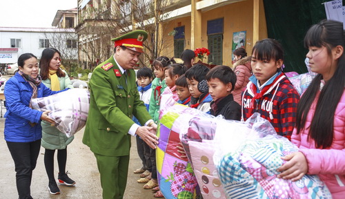 Đại tá Đỗ Đức Bình - Cục Phó Cục Tham mưu, Tổng cục Cảnh sát tặng chăn cho các em học sinh Trường dân tộc bán trú THCS Lao Và Chải.