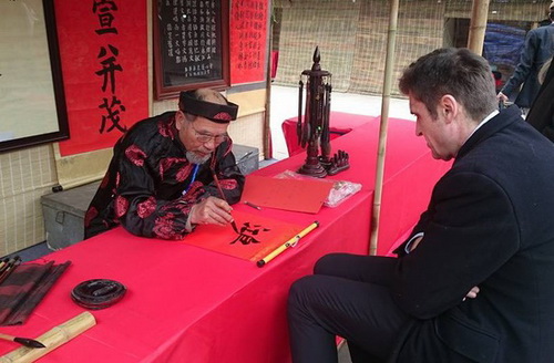 Một du khách nước ngoài xin chữ tại Hội chữ Xuân Mậu Tuất 2018 tại Hà Nội.
