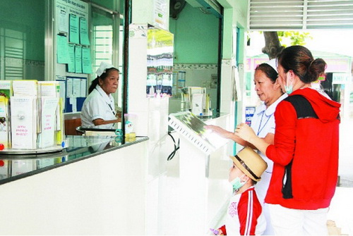 Nhân viên y tế hướng dẫn người dân sử dụng bảng điện tử.