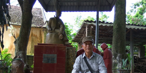 Tác giả bên tượng nhà văn Nguyên Hồng.