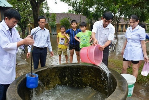 Cán bộ y tế khử trùng nước giếng tại xã Bình Chánh, huyện Bình Sơn, Quảng Ngãi.