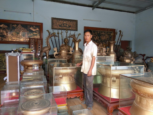 Nghệ nhân ưu tú Lê Văn Dương bên những chiếc trống đồng.