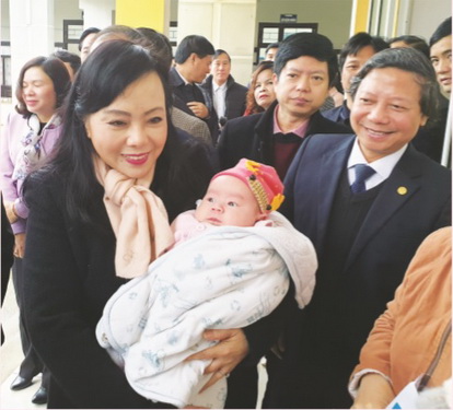 Bộ trưởng Bộ Y tế Nguyễn Thị Kim Tiến bế cháu bé vừa được tiêm chủng tại  Trạm Y tế xã Phú Nghĩa, huyện Chương Mỹ, Hà Nội.