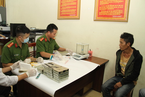 Đối tượng Hạng A Kỷ cùng tang vật là 20 bánh hêrôin cùng 400 viên ma túy tổng hợp tại cơ quan điều tra (Công an tỉnh Yên Bái).