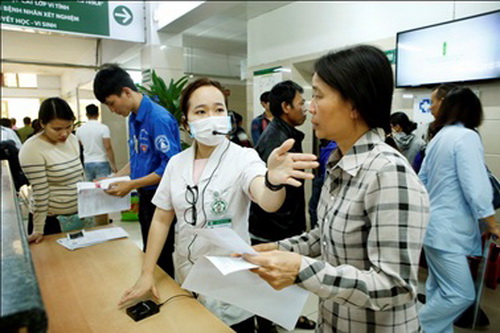 Cán bộ công tác xã hội và tình nguyện viên hướng dẫn người bệnh đến khám bệnh. Ảnh: Dương Ngọc -TTXVN