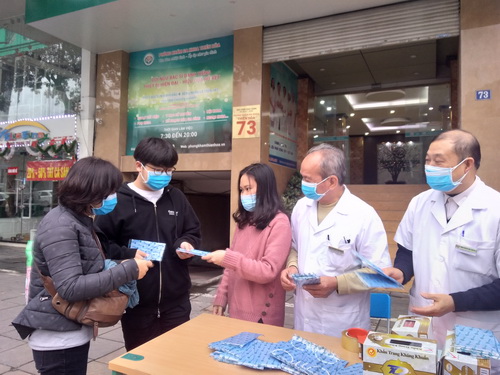 Nhân viên phòng khám trên đường Trần Duy Hưng, Hà Nội phát khẩu trang miễn phí.