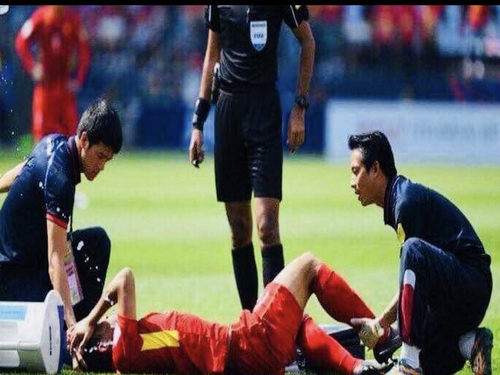 Bác sĩ sơ cứu cho cầu thủ bị chấn thương trên sân đấu.