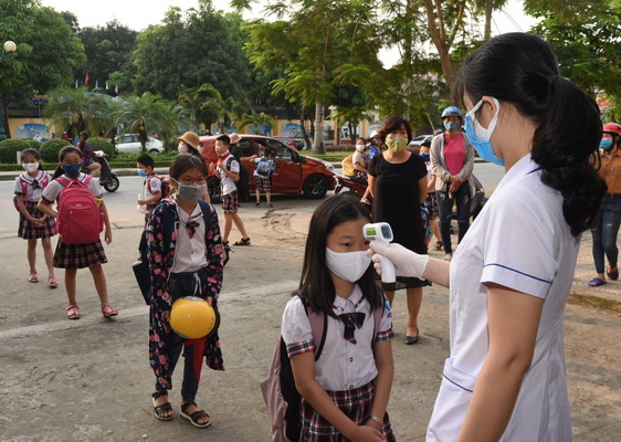 Học sinh tiểu học được kiểm tra thân nhiệt trước khi vào lớp. Ảnh: Từ Thành