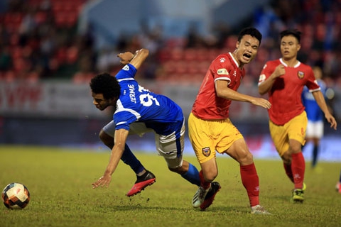 Tiền đạo Than.QN (trái) thất thế trong pha tranh bóng với hậu vệ HL Hà Tĩnh. Ảnh:  Minh Tuấn