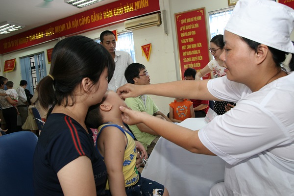 Cho trẻ uống vitamin A tại trạm y tế phường. 