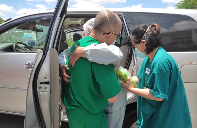 Một bệnh nhân tuổi cao được các bác sĩ bế lên xe để trở về với gia đình
