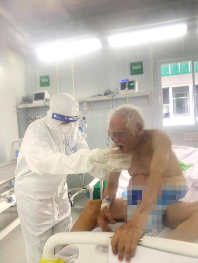 Điều dưỡng của Trung tâm hồi sức người bệnh COVID-19 Việt Đức đang bón từng thìa cháo và dỗ dành cụ T ăn. Ngoài việc chăm sóc vệ sinh, ăn uống cho bệnh nhân, các y bác sĩ còn động viên tinh thần người bệnh mỗi ngày để họ nhanh chóng hồi phục sức khỏe
