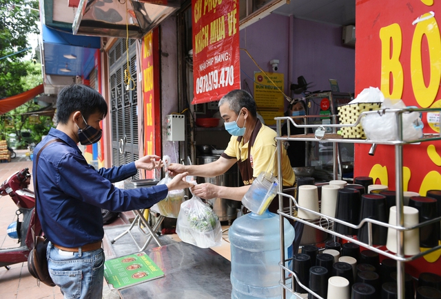 [Ảnh] Người Hà Nội xếp hàng mua phở, bún chả, sửa xe lúc 12h trưa tại 19 quận, huyện được nới lỏng - Ảnh 5.