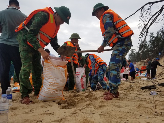 Hàng trăm chiến sĩ cùng người dân oằn mình vác bao cát gia cố bờ biển sạt lở - Ảnh 7.