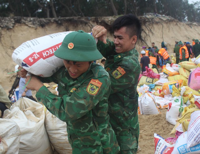 Hàng trăm chiến sĩ cùng người dân oằn mình vác bao cát gia cố bờ biển sạt lở - Ảnh 1.