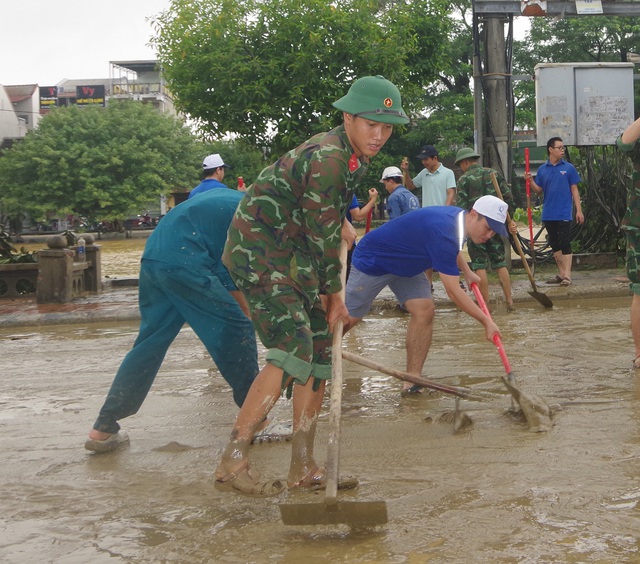 Bộ đội, công an chung tay dọn bùn đất sau mưa lũ - Ảnh 4.