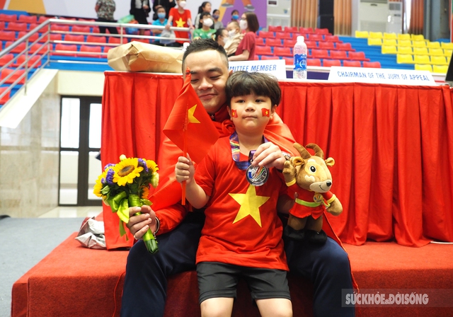 VĐV Phạm Quốc Khánh đeo huy chương cho con trai sau khi giành Huy chương Bạc  - Ảnh 2.