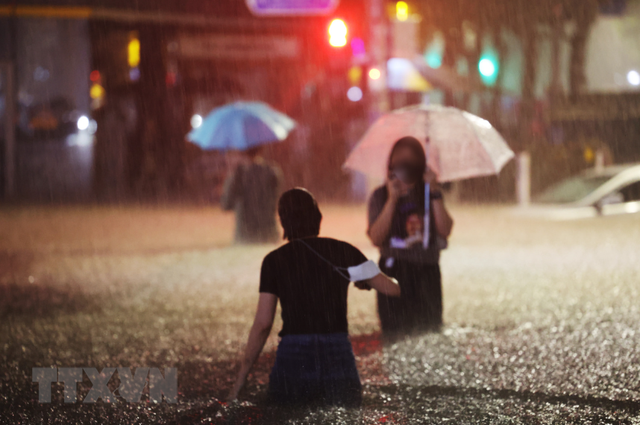 Người dân lội qua một con phố ngập lụt ở quận Gangnam, Seoul vào đêm thứ Hai. (Nguồn: Yonhap/koreaherald.com