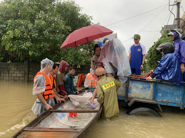 Lực lượng chức năng hỗ trợ đưa thai phụ vượt lũ đi sinh.