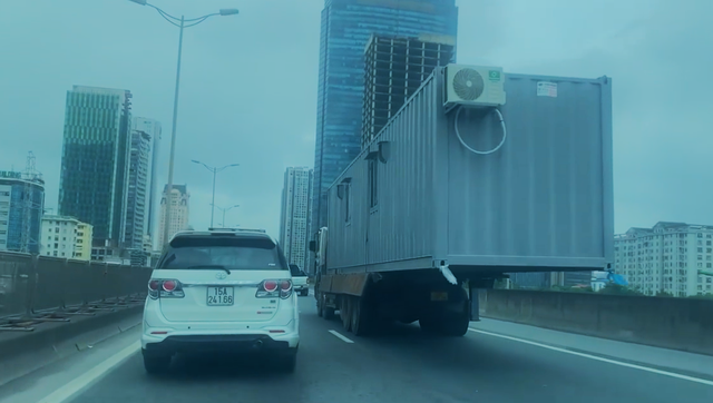 Hoảng hồn với xe tải chở container lơ lửng trên đường - Ảnh 2.