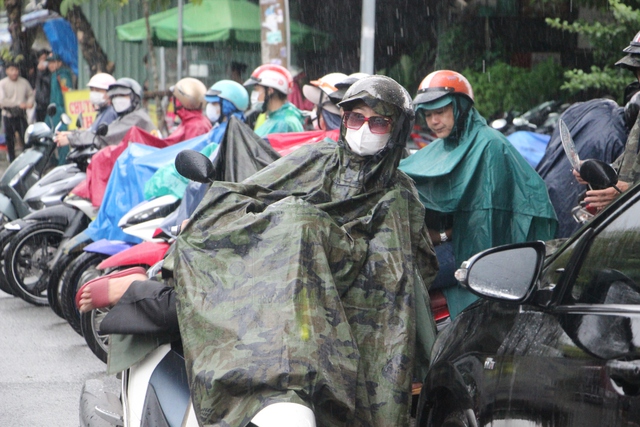TP.HCM mưa lớn: Phụ huynh đứng dưới mưa chờ đón con thi tốt nghiệp THPT - Ảnh 1.