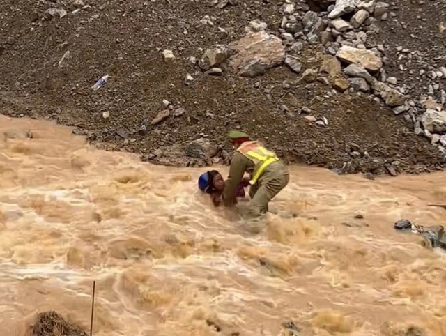 Video Thượng úy cảnh sát giao thông cứu 2 người giữa dòng nước lũ- Ảnh 1.