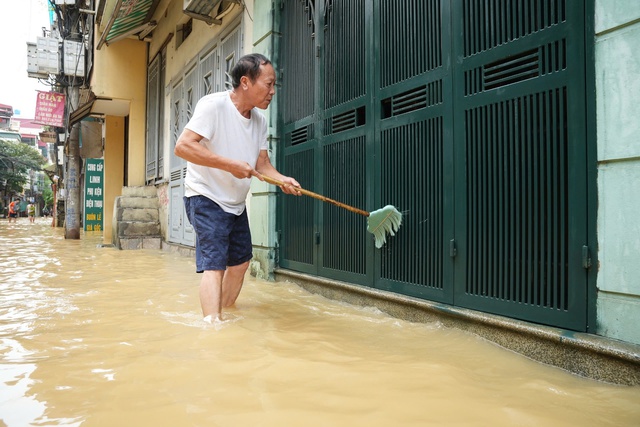 Nước rút dần, người dân ở 'rốn lũ' Hoàn Kiếm tất bật dọn dẹp, chở đồ đạc về nhà- Ảnh 2.