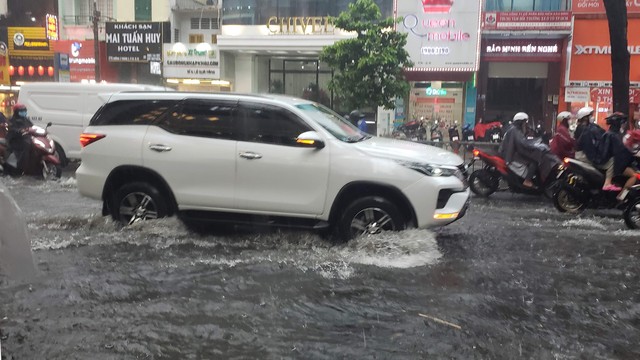 Người dân đi lại khó khăn vì đường ngập nước. Ảnh: Xuân Dự