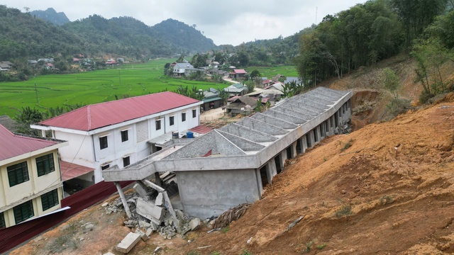 Chậm xây trường sau sạt lở, học sinh gồng mình đến lớp tạm- Ảnh 1. Chậm xây trường sau sạt lở, học sinh gồng mình đến lớp tạm- Ảnh 1.