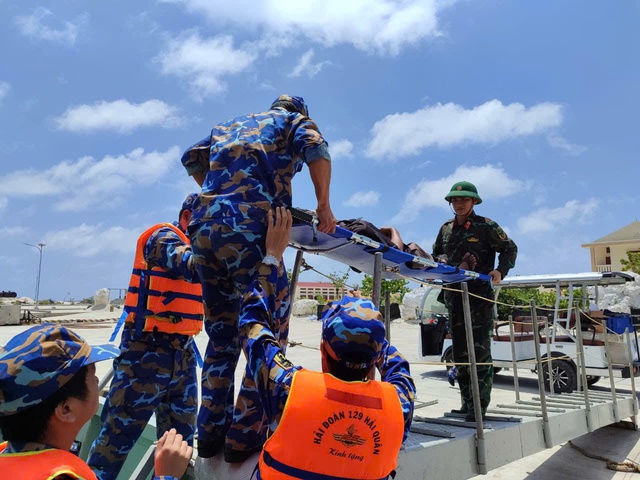 Tàu hải quân vượt sóng lớn đưa 2 ngư dân bị bệnh nặng trên biển vào đất liền- Ảnh 1.