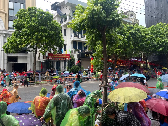 Người dân 'đội mưa' chờ xem tổng hợp luyện diễu binh, diễu hành- Ảnh 1. Người dân 'đội mưa' chờ xem tổng hợp luyện diễu binh, diễu hành- Ảnh 1.