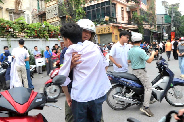 Người cha 18 năm làm đôi chân cho con, người bà 80 tuổi và những người thân thấp thỏm chờ sĩ tử thi tốt nghiệp THPT- Ảnh 1. Người cha 18 năm làm đôi chân cho con, người bà 80 tuổi và những người thân thấp thỏm chờ sĩ tử thi tốt nghiệp THPT- Ảnh 1.