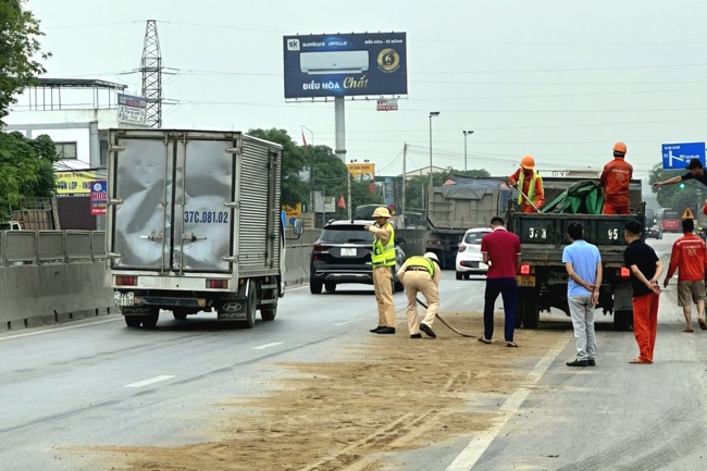 Lực lượng chức năng tổ chức phân luồng,  xử lý vết dầu loang, đảm bảo an toàn cho người tham gia giao thông.