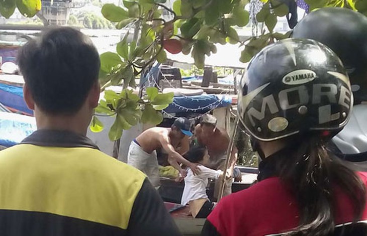 Người phụ nữ được đưa lên ghe và sơ cứu tại chỗ, may mắn thoát chết.