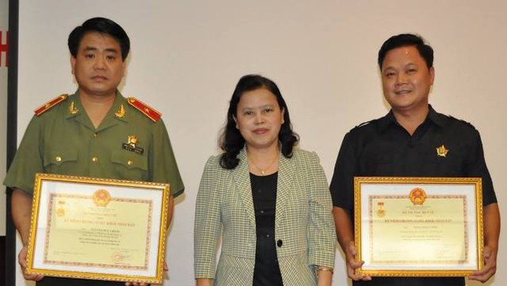 Thứ trưởng Bộ Y tế Nguyễn Thị Xuyên trao tặng kỷ niệm chương "Vì Sức khoẻ Nhân dân" cho đồng chí Nguyễn Đức Chung và Phan Anh Cường.