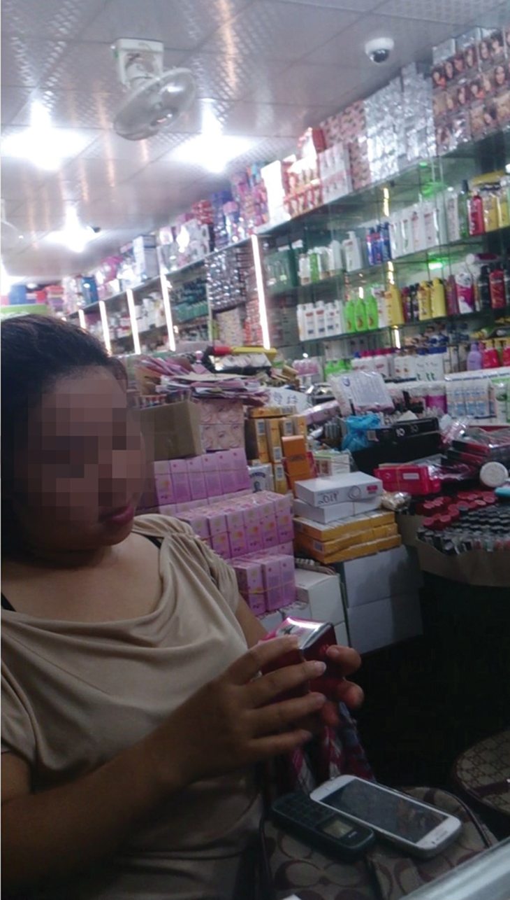Chủ sạp T.L. đang giới thiệu mỹ phẩm mau trắng da cho phóng viên